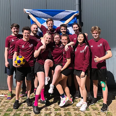 Strathclyde Korfball team with the Scotland flag raised above their heads.