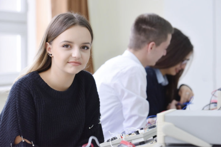 An apprentice worker appears unhappy as she looks at the camera.